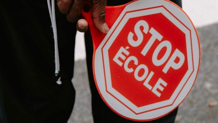 person holding red and white stop sign